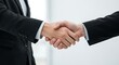 © Azwardi - Close-up of a firm handshake between two business professionals in suits, symbolizing a successful partnership, agreement, and trust