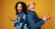 © peopleimages.com - Portrait, funny and people in studio, smartphone and laughing on yellow background. Happy friends, man and woman with smile, cellphone and comedy video with humor, joke and support with digital app