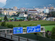 View of highway signs with the city of Innsbruck in the background.