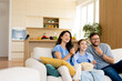 © BGStock72 - Family bonding moments while enjoying popcorn in a cozy living room