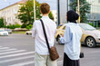© Nariman - Young adults waiting to cross the street in the city during early evening hours while dressed for warm weather
