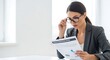 © Iis - Focused businesswoman in glasses reviewing a financial report with charts in a bright office.