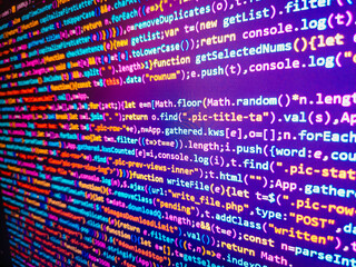 programmer working in a software develop company office. screen of green colored syntax of source co
