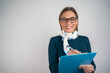 © Nenad - Beautiful smiling African businesswoman writing on clipboard while posing against isolated background in studio portrait
