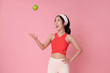 © NaMong Productions - Healthy lifestyle concept with cheerful Asian woman in sporty outfit tossing green apple symbolizing nutrition balance fitness and natural energy