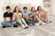 © New Africa - Happy teenage friends with snacks watching movie indoors