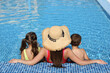 © New Africa - Woman with her children in swimming pool, back view. Summer vacation