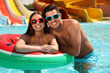© New Africa - Happy couple with inflatable ring at water park. Summer vacation