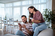 © Migma_Agency - Couple using smartphone and credit card for online shopping at home