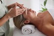 © New Africa - Beautiful woman receiving facial massage on couch in spa salon, closeup