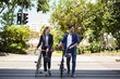 © DG PhotoStock - Asian man and woman walking with bicycles in the city on their way to work.