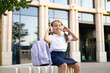 © sofiko14 - Caucasian schoolgirl wearing headphones, sitting outside the school building.