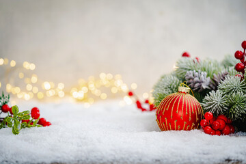 Wall Mural - christmas holiday background with snow, fir tree and decorations with christmas light behind. christ