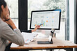 © kenchiro168 - Businesswoman presenting quarterly business growth performance chart on computer screen to colleague in modern office, discussing data analysis and strategy planning
