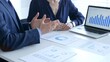 © rogerphoto - Businessman and business woman reviewing financial documents, collaborating over laptop screen, analyzing market charts for strategic corporate planning. Businesspeople and finance concept