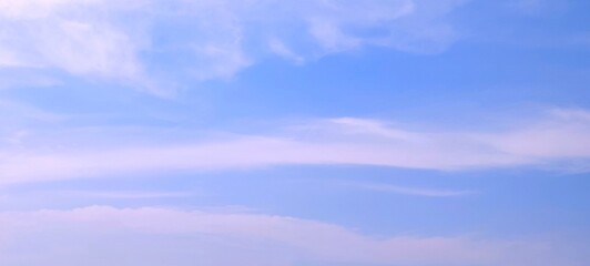Wall Mural - Panorama view of bright blue sky with fluffy white clouds on a clear sunny day. Sky panorama clear blue with white clouds in spring. Cloudscape. Clear blue sky, bright spring, wallpaper landscape.