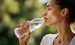 © simba kim - a young woman holding a transparent plastic water bottle and drinking fresh water.