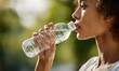 © simba kim - a young woman holding a transparent plastic water bottle and drinking fresh water.