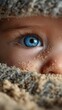 © Michael - Child's blue eye visible amidst sandy texture in close-up during a sunny day at the beach