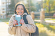 © luismolinero - Young woman at outdoors holding a passport with surprised expression