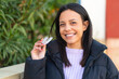 © luismolinero - Young woman at outdoors holding invisible braces with happy expression