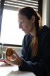 © KONSTANTIN SHISHKIN - Woman eating kiwi fruit at home