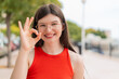 © luismolinero - Young woman with glasses at outdoors showing ok sign with fingers