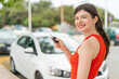 © luismolinero - Young pretty woman at outdoors holding car keys with happy expression
