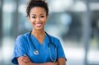 © Gatherina - Portrait of smiling african american doctor or nurse wearing scrubs and stethoscope
