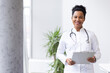 © PeopleVideos - Confident female doctor smiling and holding a clipboard, representing healthcare professionalism and expertise