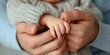 © Phatcharee - Tender moment parent holding baby's hand cozy home emotional connection intimate view