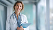 © utaem2022 - Portrait of smiling female doctor holding clipboard in hospital corridor
