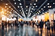 © SUPHANSA - Blurred Image of Busy Expo Hall with Vibrant Lighting and Crowded Attendees at a Trade Show Event