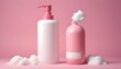 © Monster - Pink and white shampoo and soap bottles sit on a soft pink background, with white foam.