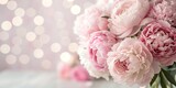 A bouquet of pink peonies flowers on a light background with bokeh