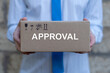 © wladimir1804 - Business person holds cardboard box with the word APPROVAL wrtitten on it. Approval Efficiency Policy Progress Business Concept. Approved document or agreement.