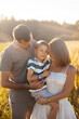 © verona_studio - Family enjoying a sunny day outdoors in a golden field while embracing moments of love and connection