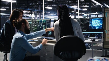 Data center software developers using machine learning algorithms to analyze large datasets. Server hub IT experts cooperating, using AI neural networks to recognize data patterns, camera A