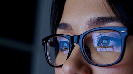 Closeup of a womans eye reflecting a computer screen with data