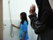 © airdone - Asian muslim girl teaching her little sister to do wudu or ablution, cleaning before salat prayer