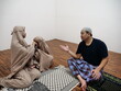 © airdone - Asian muslim father talking to his daughters after salah pray, communication discussion giving advice