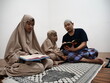 © airdone - Asian muslim father teaching his daughter how to read recite Quran
