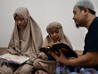 © airdone - Asian muslim father teaching his daughter how to read recite Quran