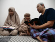 © airdone - Asian muslim father teaching his daughter how to read recite Quran