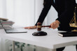 © Kritdanai - Attractive young lawyer in office Business woman and lawyers discussing contract papers with brass scale on wooden desk in office. Law, legal services, advice, Justice and real estate concept.