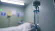 © Febifitri - Close-up of IV drip in a blurred hospital room with an empty bed