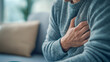 © AgungKY - Man experiencing chest pain holds hand on chest and feels unwell