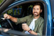 © Maria Vitkovska - Happy businessman drinking coffee while driving modern car