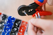 © wifesun - Electrician using crimping pliers to connect an electrical wire to a connector, with a box of various connectors in the background, during the process of connecting an electric stove
