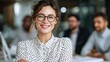 © Johannes - confident smiling business woman wearing eyeglasses and white polka dotted shirt seated with folded arms beside male coworkers at work no logos no brands ar 169